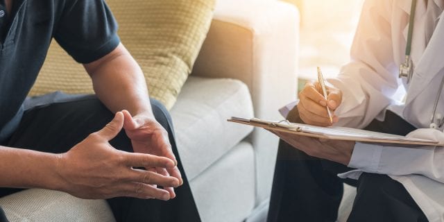 Man speaking with a doctor in an office about treatment resistant depression to explore other options besides medication.