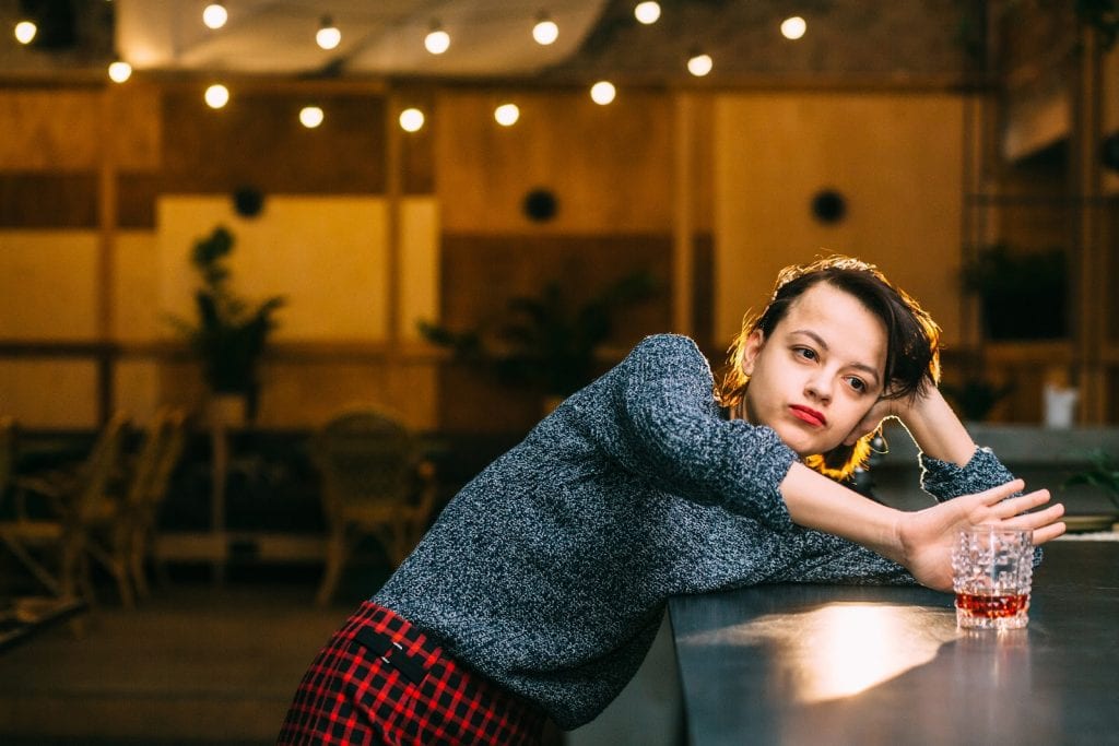 drunk woman alone refusing a drink