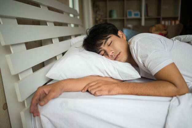 Man sleeping on bed in the morning Your sleep and your mental health can often go hand in hand.