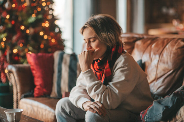 Portrait of candid authentic smiling boy teenager having fun emotion at wooden lodge Xmas decorated
