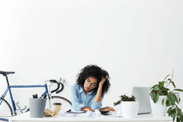 People, business and modern technology. Sad beautiful female secretary looking unhappy, having a lot of paperwork to do, feeling tired already, sitting at desk with laptop, digital tablet and papers Just because someone can hide their depression doesn't mean it isn't serious.